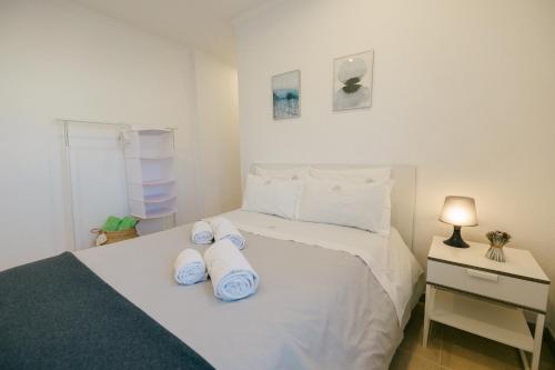 セジンブラにあるTree House - Casa Figueiraのタオルが敷かれた白いベッドのある寝室
