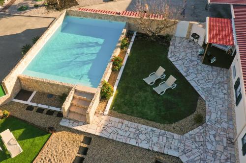an overhead view of a swimming pool with a lawn and chairs at Tree House - Casa Figueira in Sesimbra