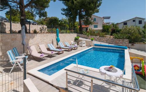 una piscina con sedie e un tavolo accanto ad essa di Lovely Home In Maslinica With Wifi a Maslinica