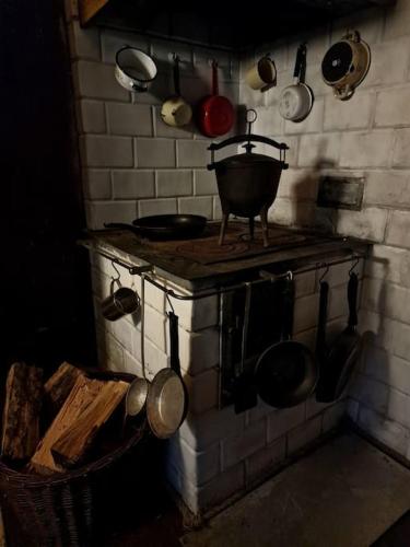 a kitchen with pots and pans hanging on the wall at Ślimakowa chatka jak u babci in Parczew