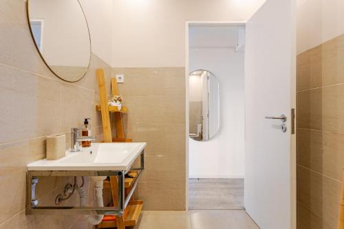 a bathroom with a sink and a mirror and a shower at Serpa Downtown Gaia in Vila Nova de Gaia