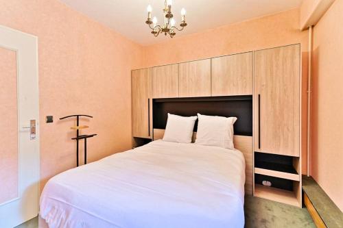 - une chambre avec un grand lit blanc et une tête de lit dans l'établissement Appartement #Vaugirard Mairie du 15ème - II, à Paris