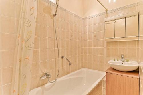 une salle de bain avec une baignoire et un lavabo dans l'établissement Appartement #Vaugirard Mairie du 15ème - II, à Paris