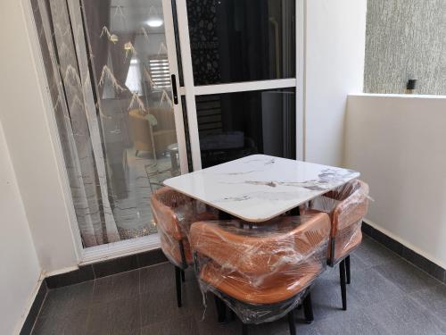 a table and two stools in front of a window at Winslow Luxury apartments with Wifi connection and a gorgeous Lake sunset view in Kampala