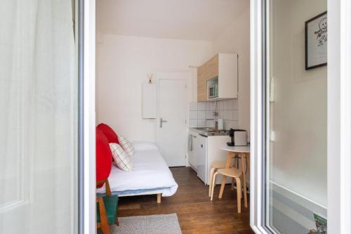 Ce petit appartement comprend une cuisine et une table. dans l'établissement Chic & bright studio Saint-Georges, à Paris