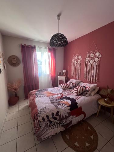 une chambre avec un lit et un mur rose dans l'établissement Maison La Chapelaude, à La Chapelaude