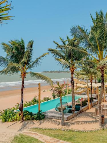 a resort with palm trees and a beach at Villa Mango in Icaraí