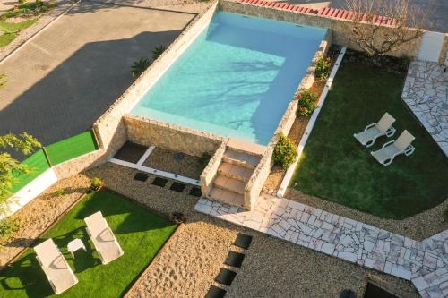 an overhead view of a swimming pool with two lawn chairs at Tree House - Casa Limoeiro in Quinta do Conde