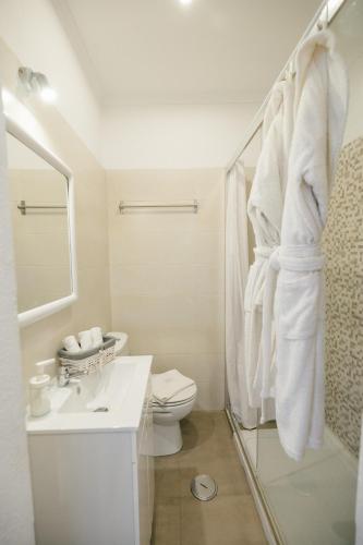 a white bathroom with a sink and a toilet at Tree House - Casa Laranjeira in Quinta do Conde