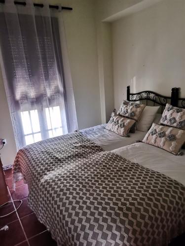 a bedroom with a large bed and a window at Casa rural Isabel, en Sierra de Grazalema in Benaocaz