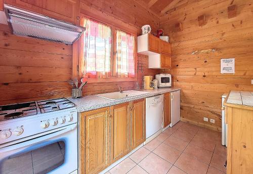 - une cuisine avec une cuisinière et un évier dans une cabine dans l'établissement Clevie, à Morzine