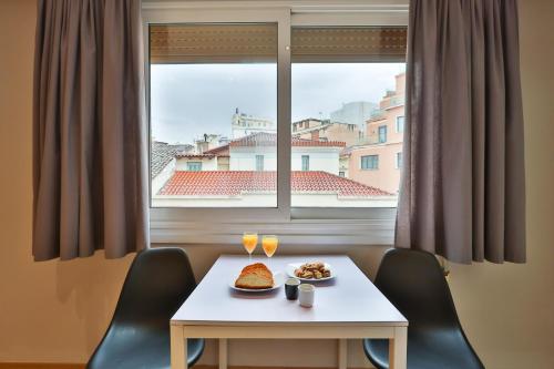 una mesa con comida y bebida frente a una ventana en 1 BD Athens Nikiou Cosy Apartment by Live&Travel, en Atenas