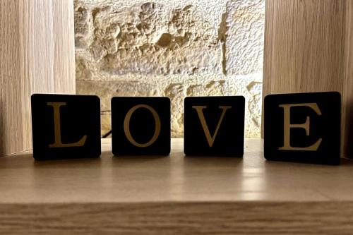 a block spelling the word love sitting on a table at Le Troglochill in Belvès