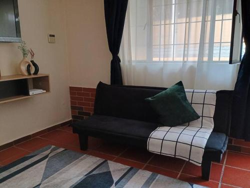 a couch in a living room with a window at Apartamento amplio en el corazón de Usaquén in Bogotá