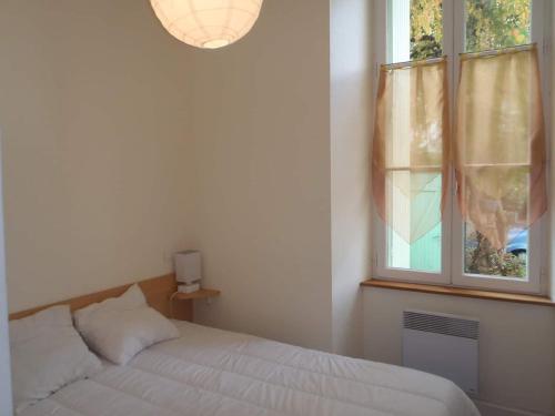 une chambre avec un lit et une fenêtre dans l'établissement Eth Polit, à Luchon