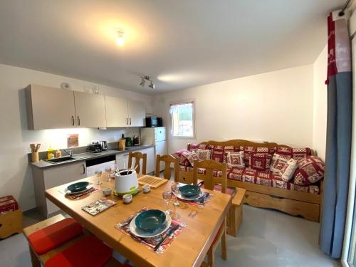 Il dispose d'une cuisine et d'un salon avec une table et des chaises en bois. dans l'établissement Appartement moderne et confortable avec navette au pied, à Samoëns ! - FR-1-624-113, à Samoëns