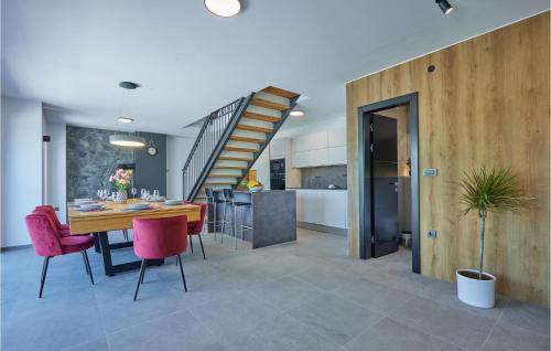 a dining room and kitchen with a wooden table and pink chairs at Lovely Home In Bedenica With Jacuzzi in Bedenica