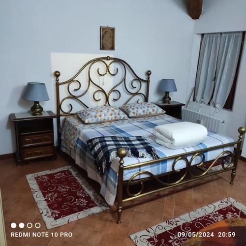 a bedroom with a bed and two lamps and two windows at Villa Cipressi del 1800 appartamento 7 posti letto in Ruina