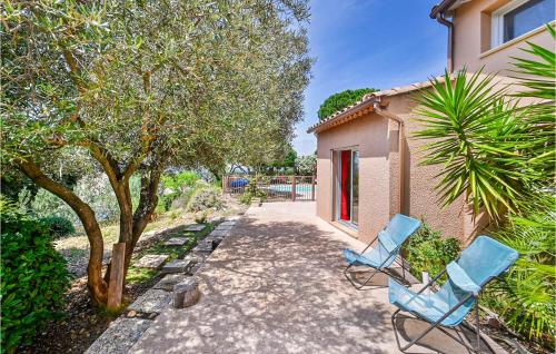 2 chaises bleues assises à côté d'une maison dans l'établissement Gorgeous Home In Eyragues, à Eyragues