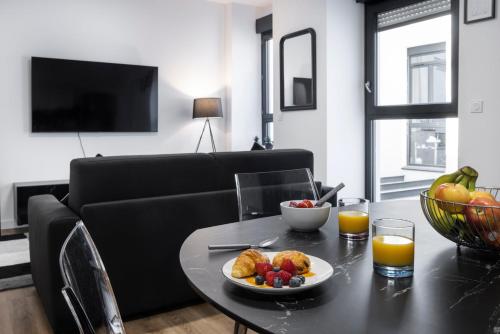 - une table avec un bol de fruits et un bol de jus d'orange dans l'établissement Suite Carla - Superbe appartement à Cannes, à Cannes