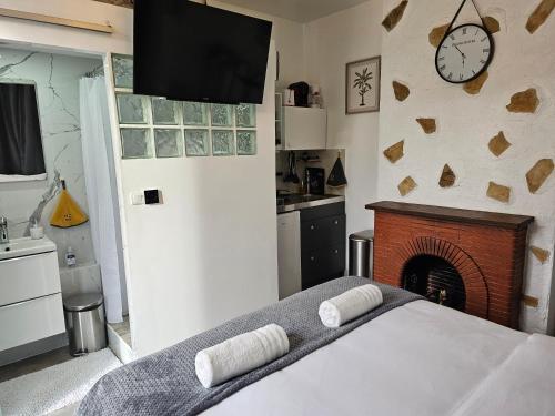- une chambre avec un lit, une cheminée et une télévision dans l'établissement Studio 3 à La Trinité proche de Nice 10 mn, Monaco 15 mn et l'Italie 30 mn, à La Trinité