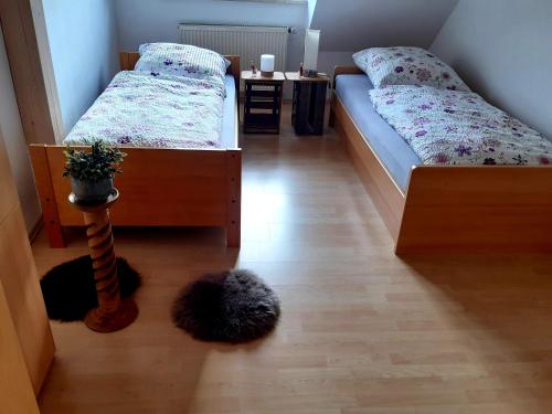 a bedroom with two beds and a plant on the floor at Ferienwohnungen "Weingenuss" für 1 bis zu 10 Personen direkt im Weingut in Sulzfeld am Main