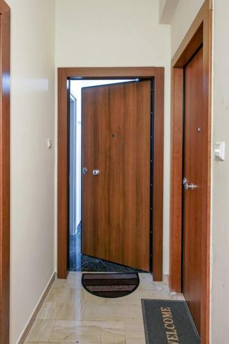 a hallway with a wooden door with a mat in front at Newly Renovated 2-Bedroom Condo In Athens ! in Athens