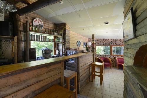 un bar dans un restaurant avec des murs en bois dans l'établissement Auberge de Jeunesse HI Séez, à Séez