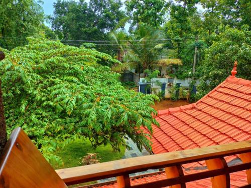 an orange roof of a house with a tree at Telma Beach Homestay in Mararikulam