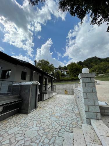 a stone patio with a stone wall and a building at Marosa Guesthouse in Tríkala