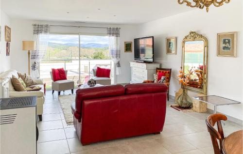 a living room with a red couch and a table at 2 Bedroom Cozy Home In Saint Chinian in Saint-Chinian