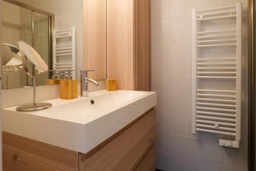 une salle de bain avec un lavabo blanc et un miroir dans l'établissement jolie maison avec jardin la pironniere 6 personnes, à Les Sables-dʼOlonne
