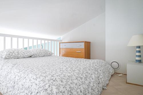 une chambre blanche avec un lit et une commode dans l'établissement jolie maison avec jardin la pironniere 6 personnes, à Les Sables-dʼOlonne