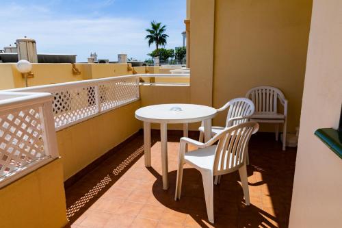 a balcony with a table and chairs on a roof at Ramada Hotel & Suites by Wyndham Costa del Sol in Fuengirola