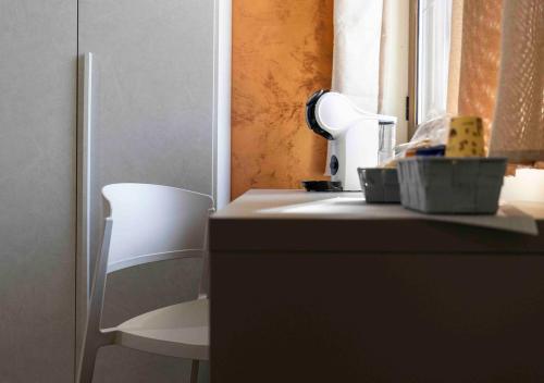 una cucina con bancone e sedia bianca di Affittacamere Melara a Serre