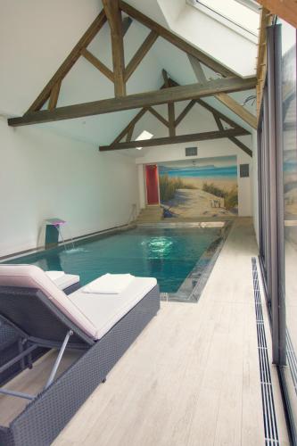 - une piscine dans une pièce avec une table et des chaises dans l'établissement Le Clos des Montants, à Meurville