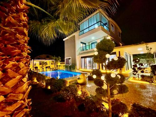 a large house with a swimming pool in front of it at Villa Annabèll1 with Swimming pool and Jacuzzi, 3 floors in Belek