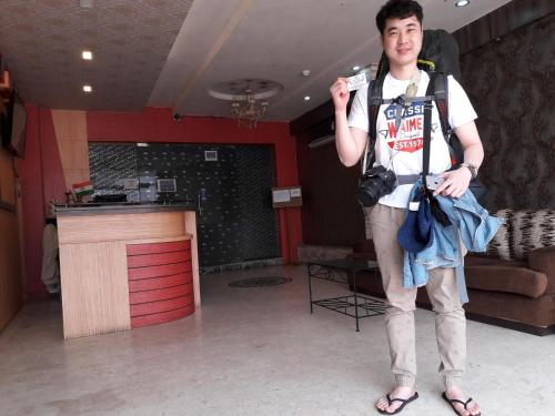 a man standing in a room with a camera at Hotel Eastern Plaza in Kolkata