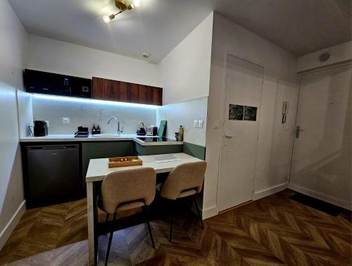 une petite cuisine avec une table et deux chaises dans l'établissement Suite Élégante au Cœur de Vienne, à Vienne