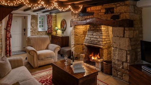 a living room with a stone fireplace at Wyck Cottage in Bourton on the Water