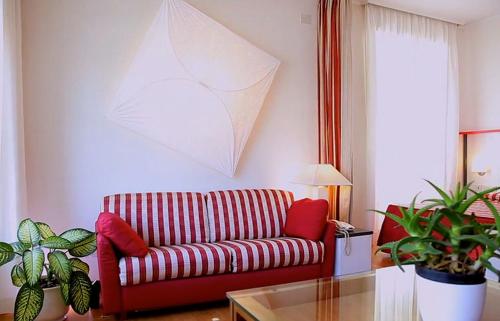 a living room with a red couch and some plants at Pràti Home in Rome