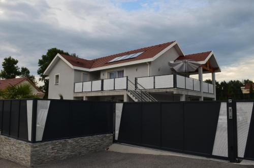 a house with a black gate in front of it at Appartement de 70 m2 dans maison comptenporaine in Charnècles