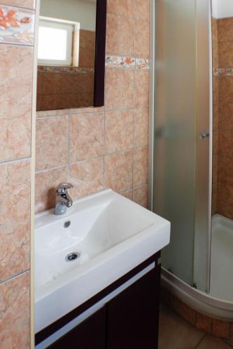 a bathroom with a white sink and a shower at apartmant Clinton in Igrane