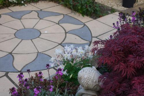 a garden with a stone walkway with a flower design at Belle-Vue in Glastonbury