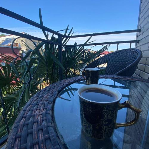 a cup of coffee sitting on top of a table at Guest House Deme in K'obulet'i