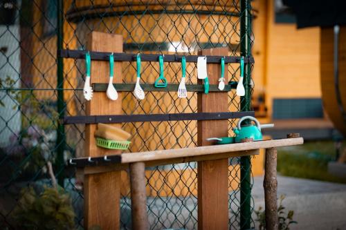 a wooden bench with utensils hanging from a fence at Tinyhouse u Nosála in Kocléřov