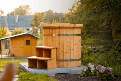 a wooden structure with two benches in a garden at Tinyhouse u Nosála in Kocléřov