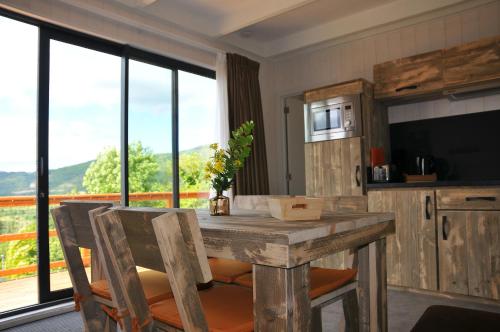 a kitchen with a table with chairs and a large window at Lodges Arverne in Vic-le-Comte