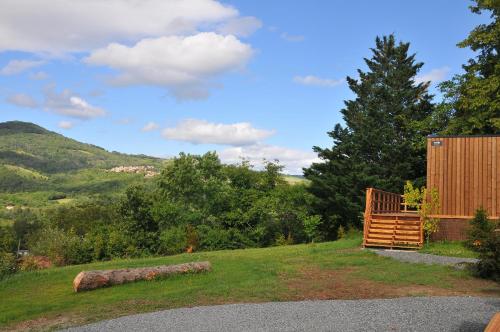 a wooden building on a hill with a tree at Lodges Arverne in Vic-le-Comte