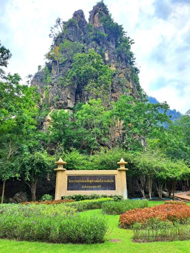 a sign in a park with a mountain in the background at The cabana guesthouse in Cha Am